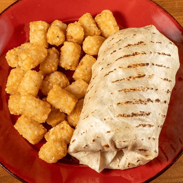 Grilled burrito and crispy tater tots on a red plate at Angie's Restaurant.