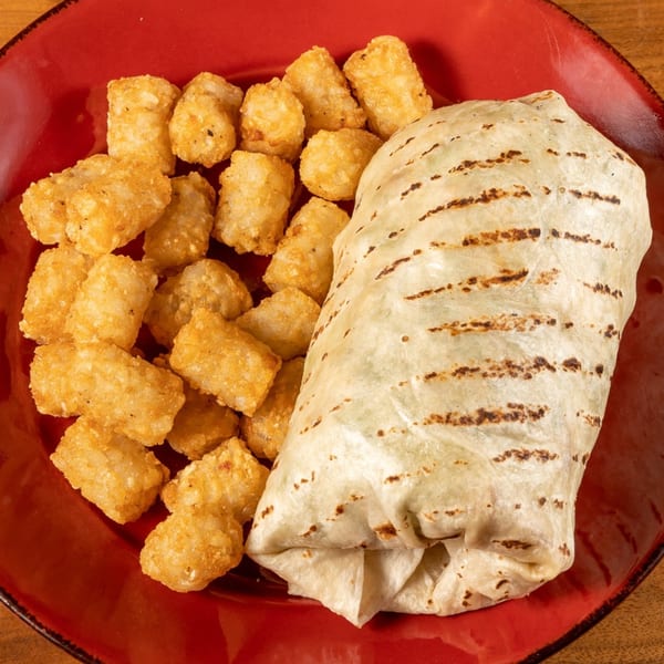 A grilled burrito and crispy tater tots served on a vibrant red plate at Angie's Restaurant.