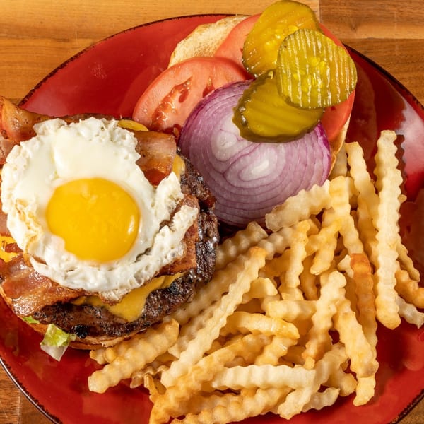 Angie's Restaurant & Pizzeria's burger with a fried egg, bacon, cheese, and crinkle-cut fries.